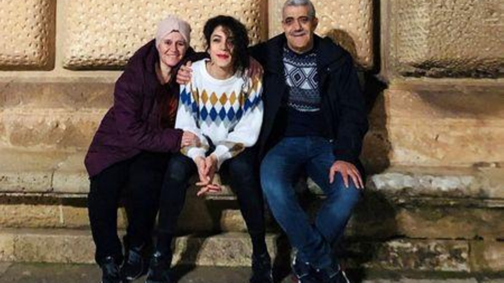  الصحفية في رويترز رهام الكوسى (في المنتصف) بين والديها في صورة 